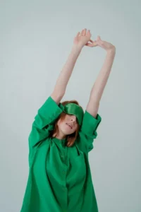 Woman stretching with arms raised — exercise and movement for mental and physical wellbeing